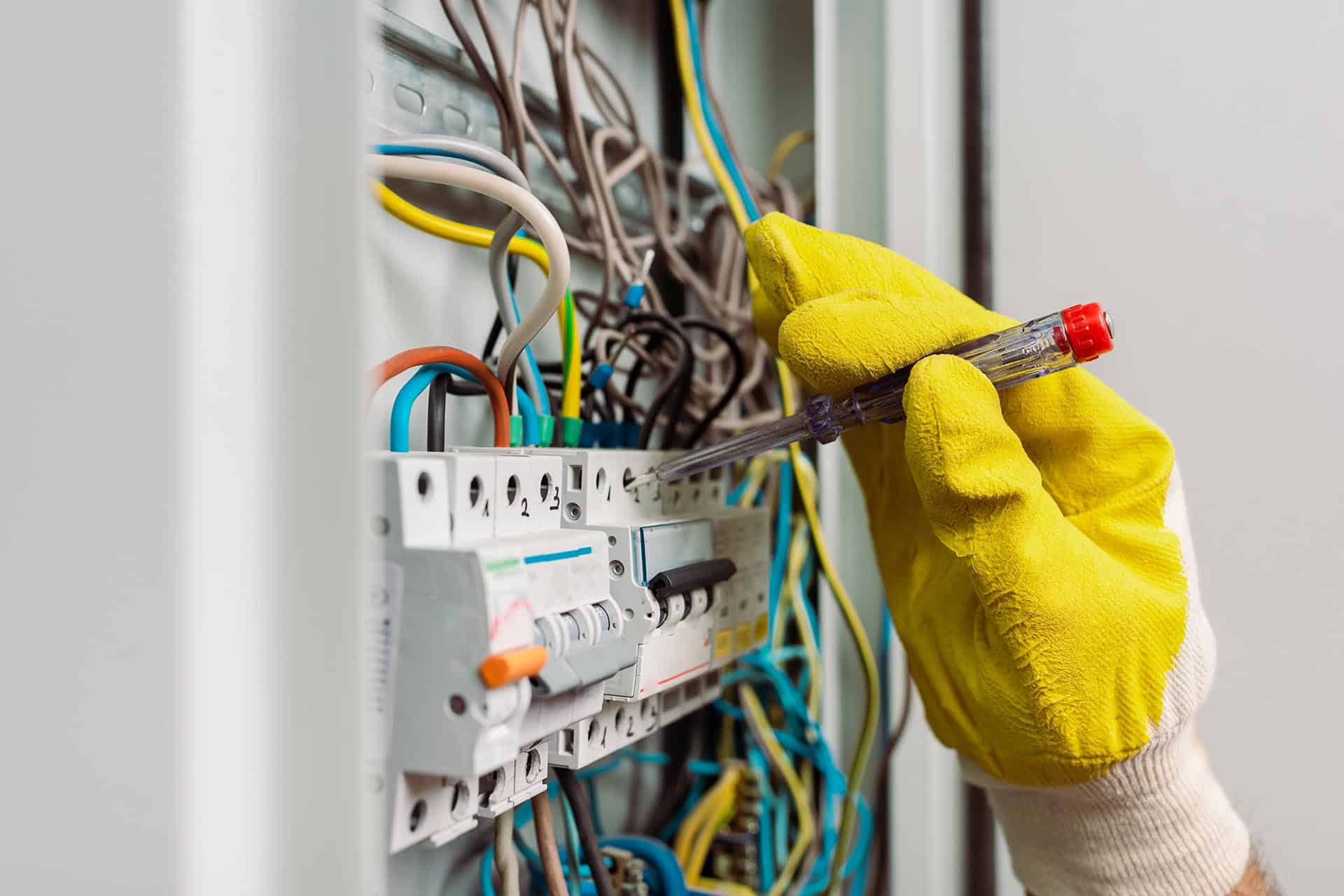 Elektriker med skruetrækker i el-tavle